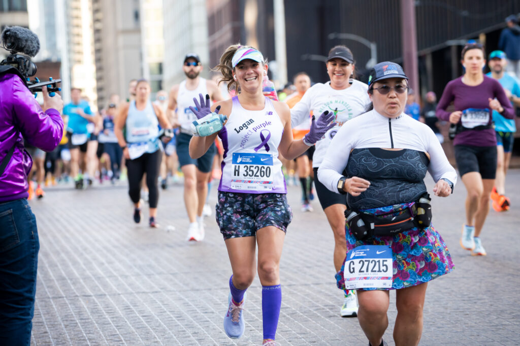 Chicago Marathon Runner on bridge with hands up supporting pancreatic cancer charity Project Purple