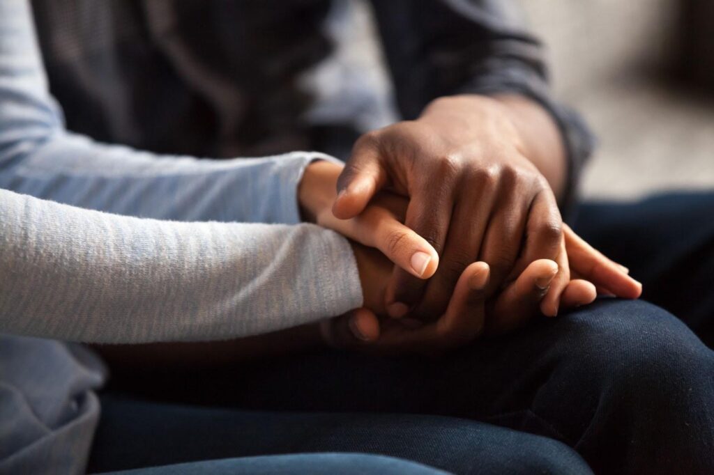 patient and loved one holding hands