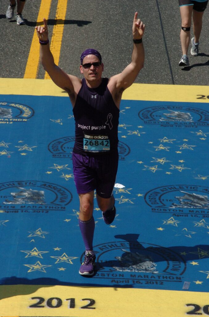 Project Purple CEO & Founder Dino Verrelli crossing the finish line at the 2012 Boston Marathon