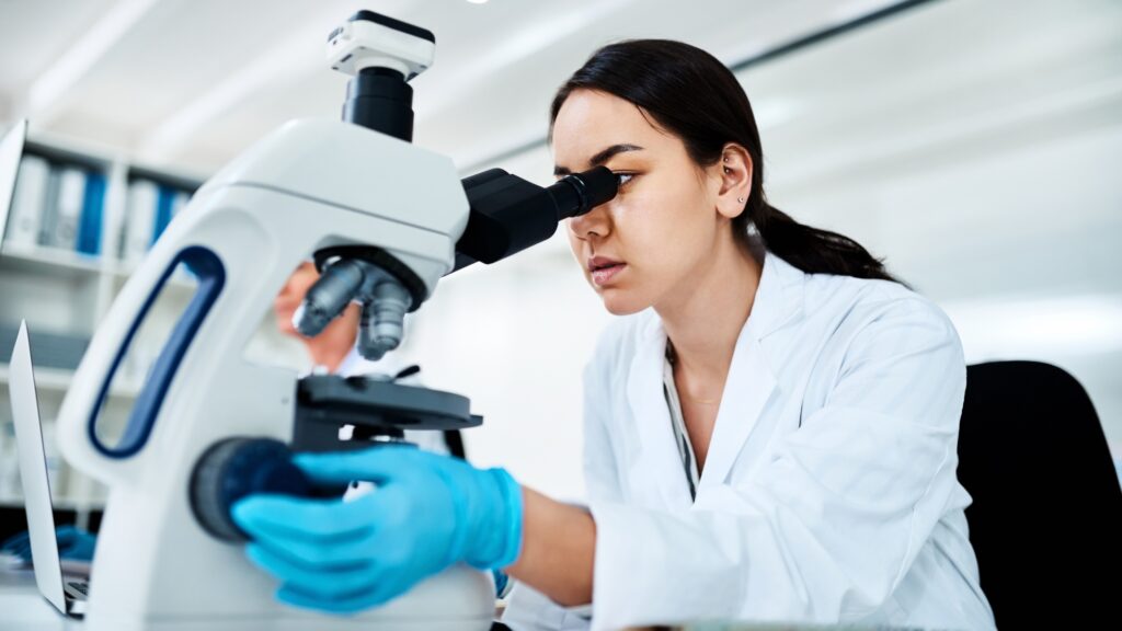 doctor studying microscope clinical trial