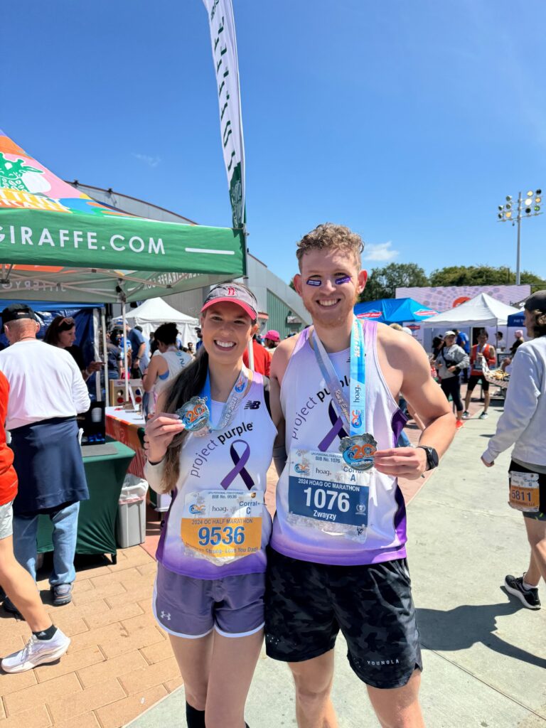 Project Purple runners holding up OC Marathon medals